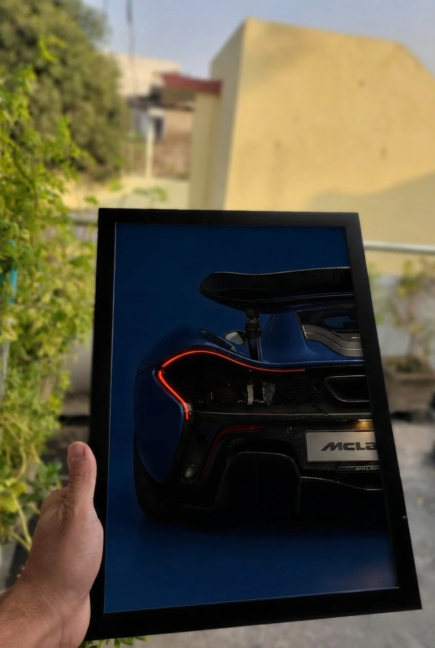Framed picture of a blue supercar held by a hand outdoors for boys room decor