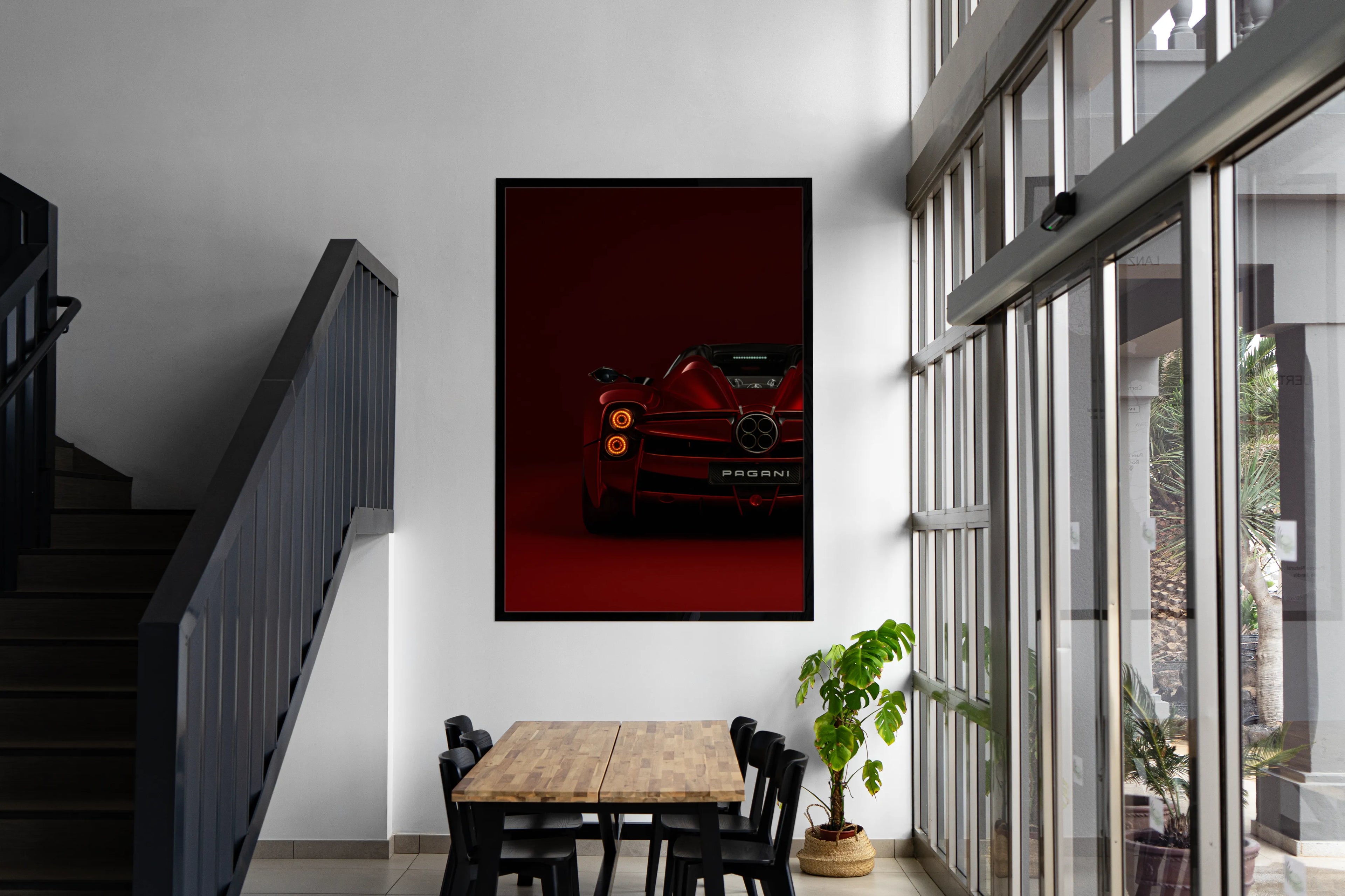 Modern interior with a red car painting on the wall, wooden table, and chairs.